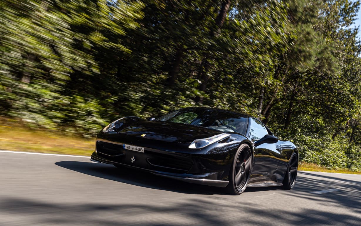  Zwarte Ferrari die rijdt in de bossen.